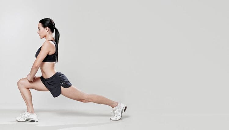 Femme réalisant un étirement du quadriceps en position de fente avant