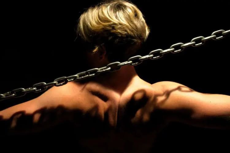 Représentation des chaînes musculaires à travers une femme vue de dos avec une chaîne en acier, illustrant l’approche globale du corps en prévention des blessures