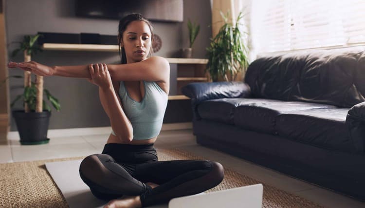 femme faisant un étirement des épaules pour prévenir les blessures en musculation