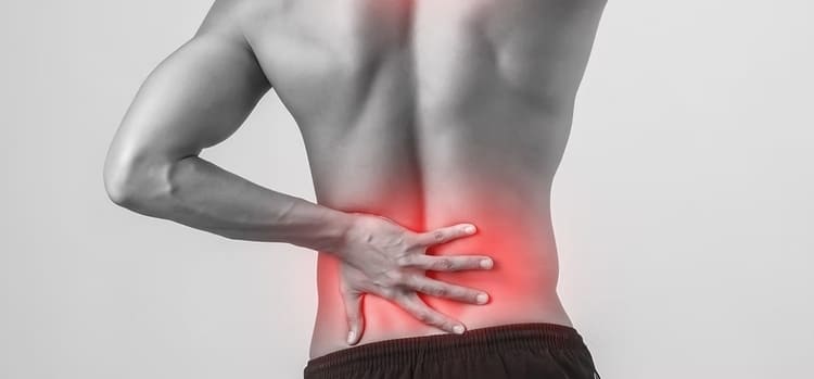 Homme tenant son bas du dos en raison d'une douleur au psoas iliaque, zone lombaire mise en évidence en rouge