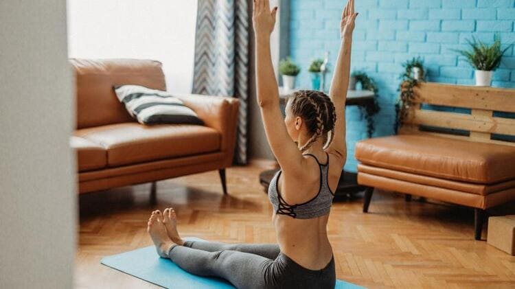 Femme réalisant des exercices lombaires à domicile sur tapis bleu pour améliorer la mobilité du dos