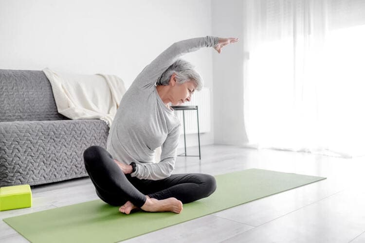 Femme réalisant un étirement latéral du tronc lors d'une séance de mobilité avec un coach sportif à Paris