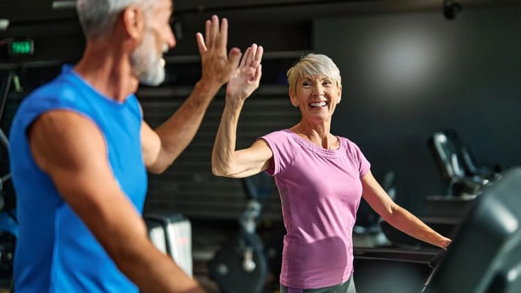 Récupération sportive et âge : couple de seniors s'entraînant ensemble en salle de sport