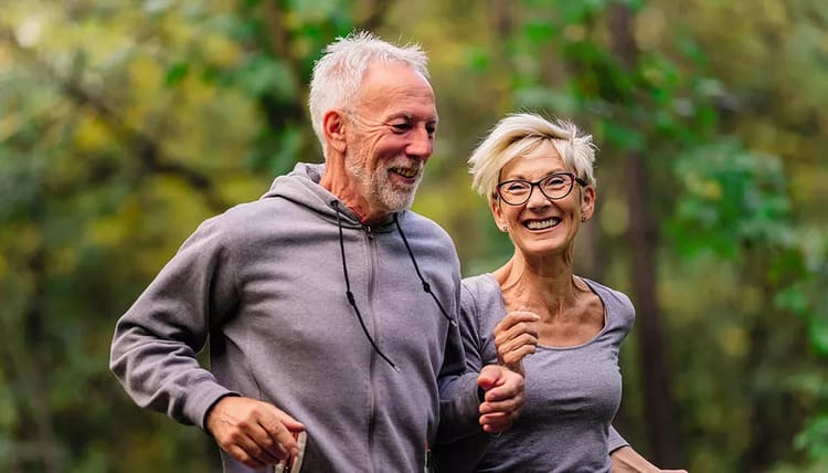 Sport et longévité : couple de seniors marchant ensemble en pleine nature