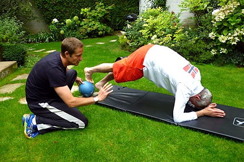 Coach sportif à Paris accompagnant des étirements assistés en intérieur et en extérieur