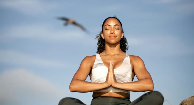 Femme en posture de méditation et de respiration profonde, illustrant la pratique de la respiration diaphragmatique pour sportifs