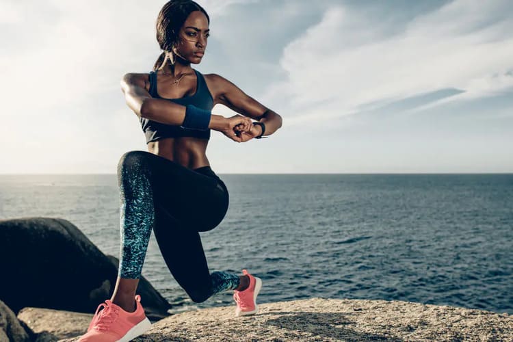 Femme effectuant une fente dynamique pour travailler la mobilité des hanches et des jambes